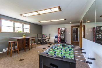 Comfortable community room with foosball table, TV, and plenty of seating for entertaining.